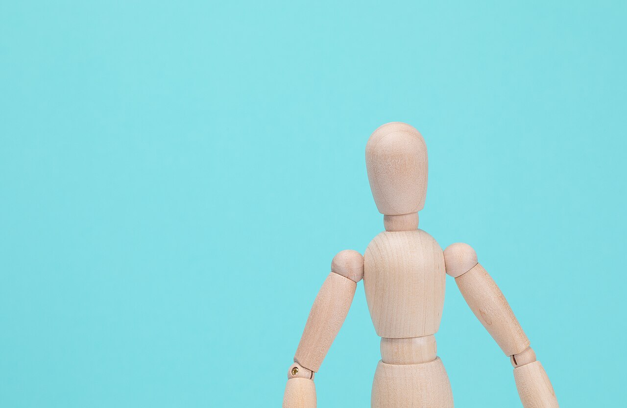 An articulated wooden artist’s manikin on a turquoise background, photographed by Jernej Furman in August 2023.