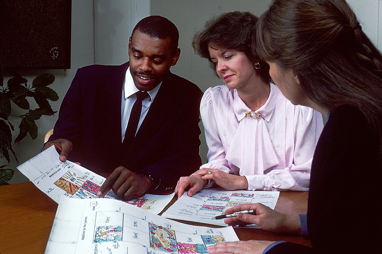 A group discusses illustrated storyboards in a National Cancer Institute photograph from November 1988.