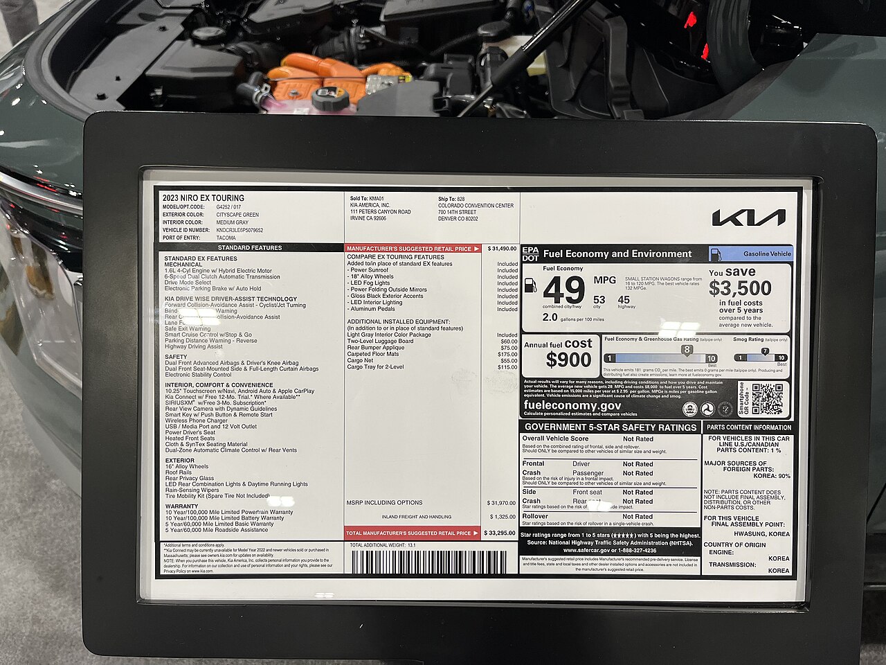 A 2023 Kia Niro EX Touring window sticker displayed at the Denver Auto Show in April 2023.