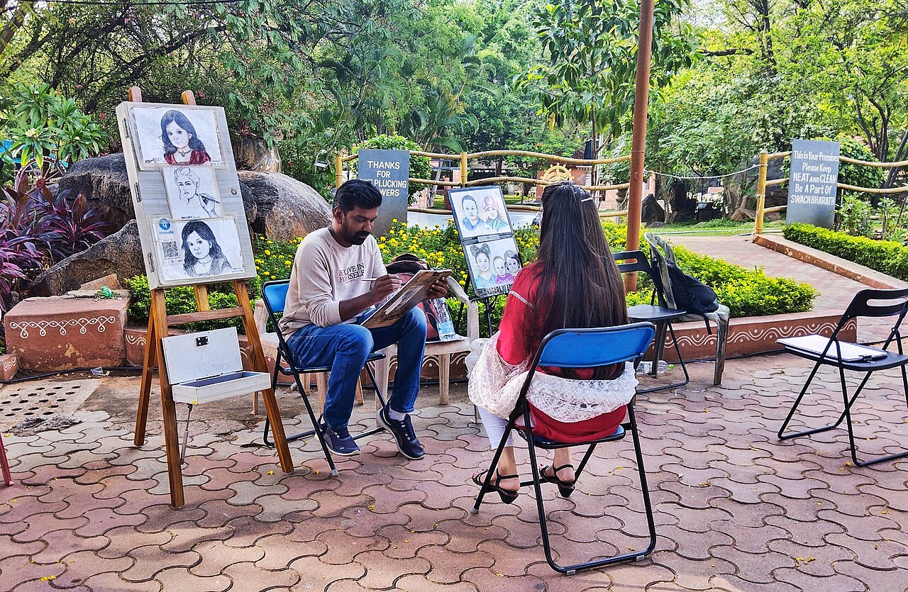 An artist drawing a client’s portrait at Shilparamam village.