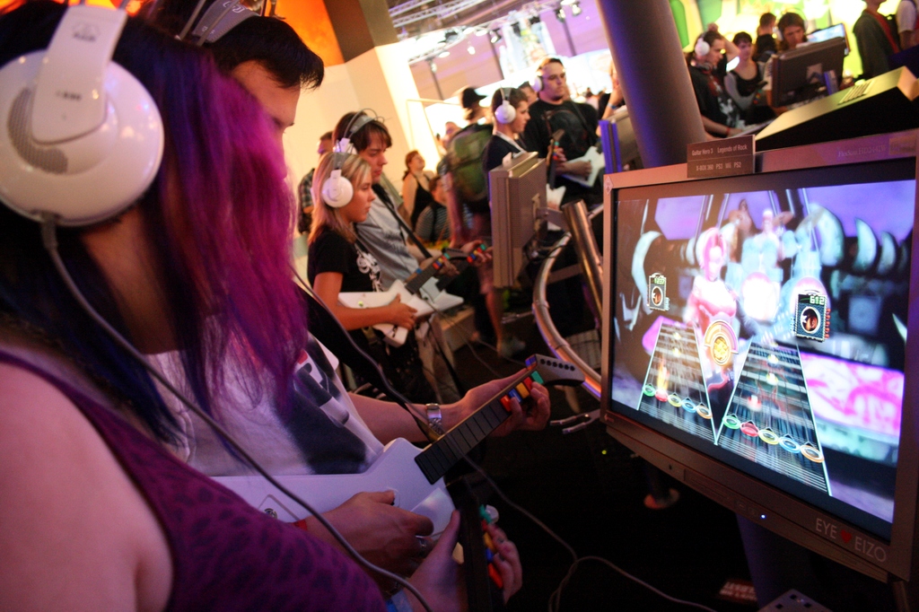 A visitor trying Guitar Hero at a gaming event.
